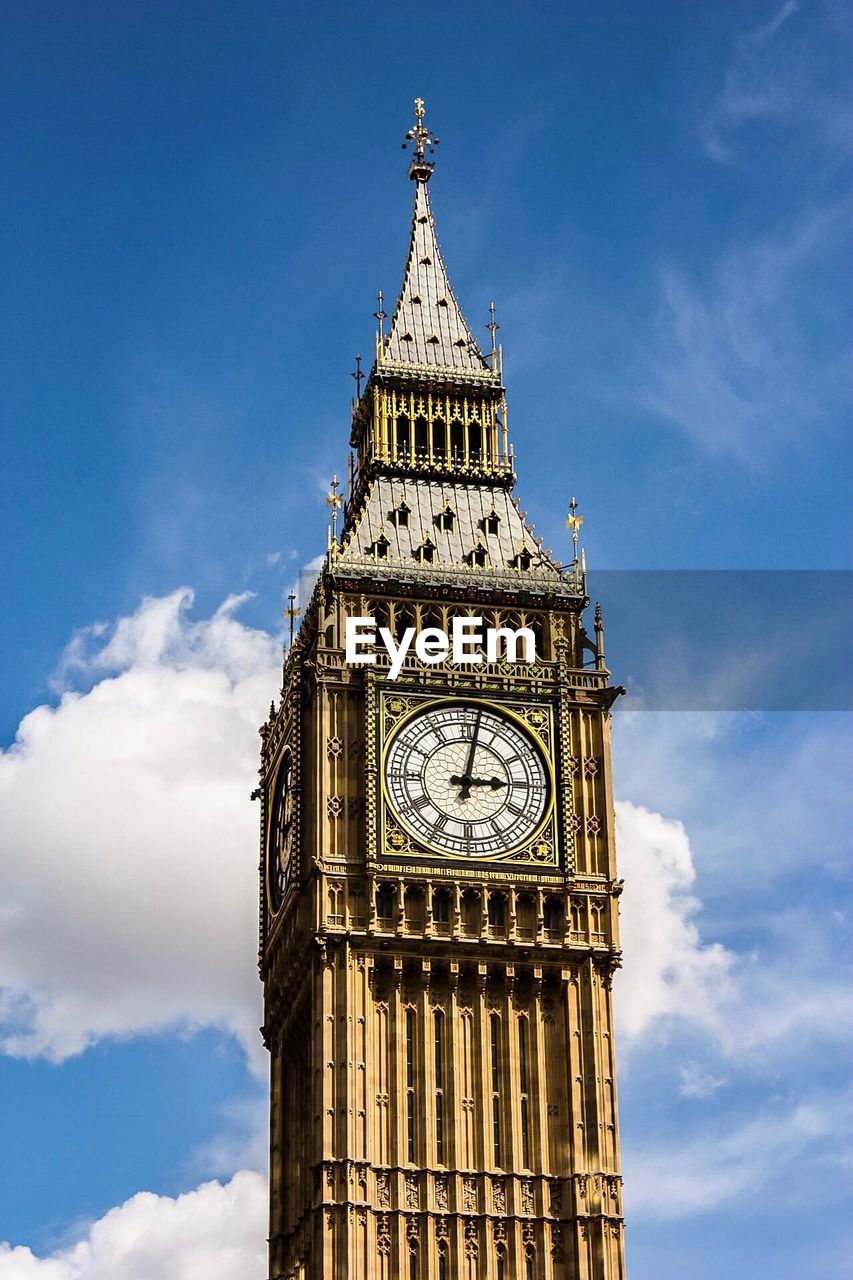 LOW ANGLE VIEW OF CLOCK TOWER AGAINST CLOUDY BLUE SKY