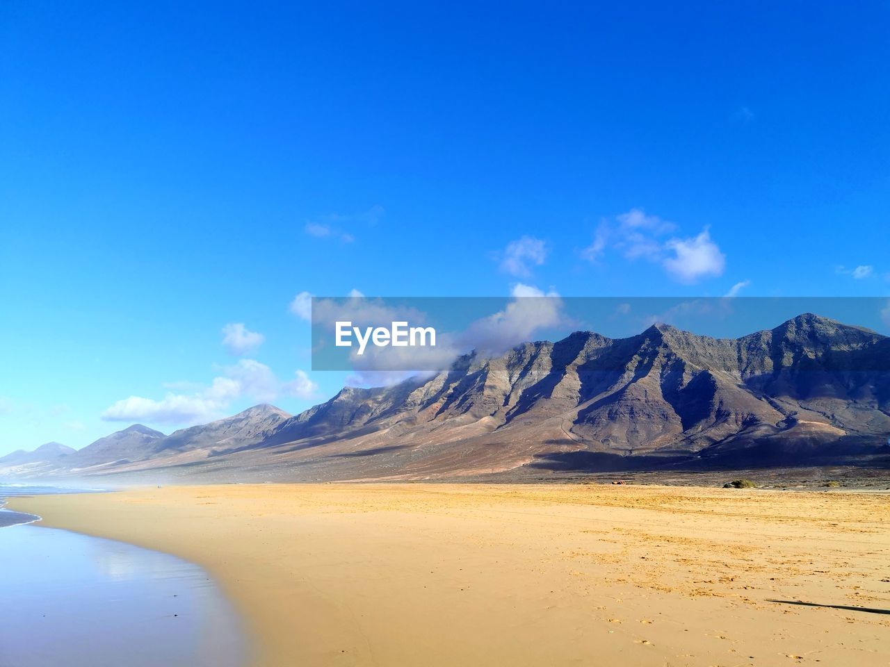 Scenic view of mountains against blue sky