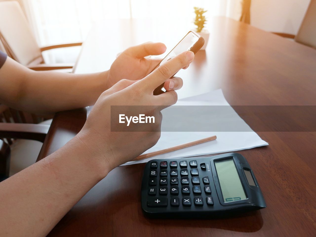 Person using mobile phone at table