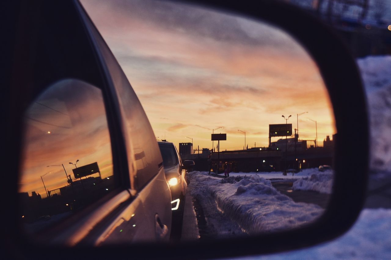 Close-up of car and snow against sky reflection in mirror