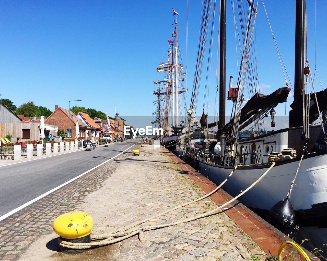 Boats moored in harbor by street in town