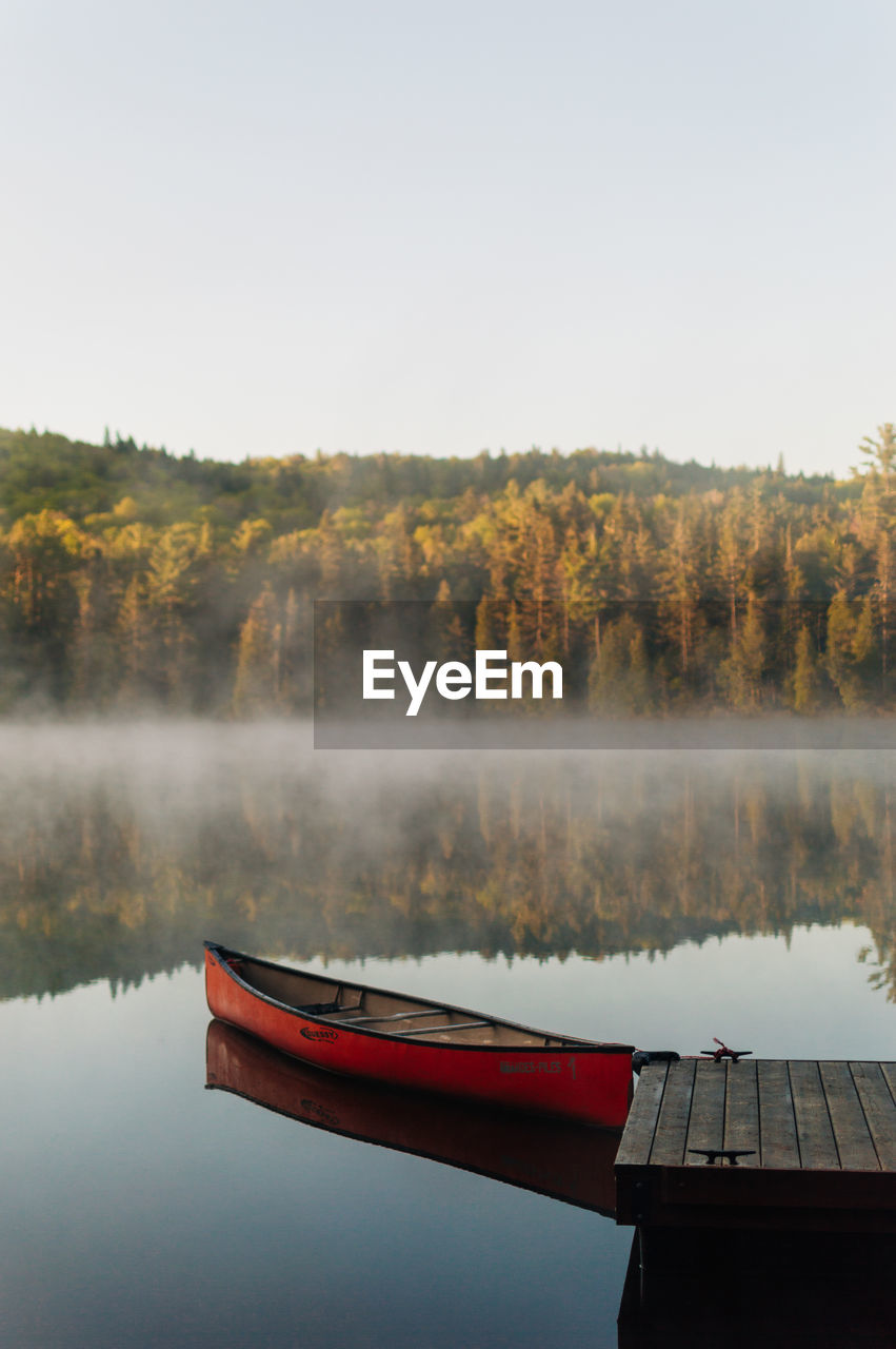 Morning view on lake with canoe and fog