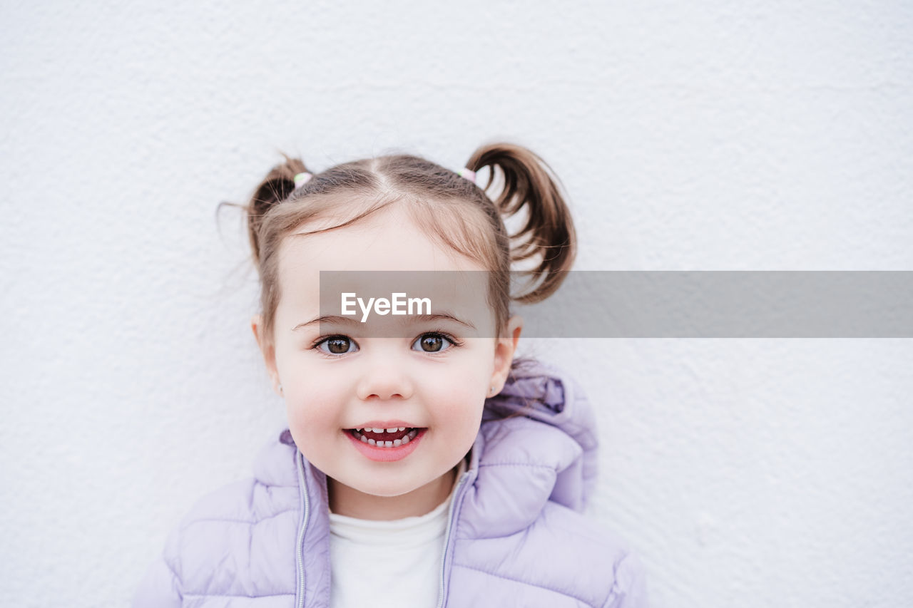 Portrait of beautiful caucasian two year old baby girl smiling over white background. childhood