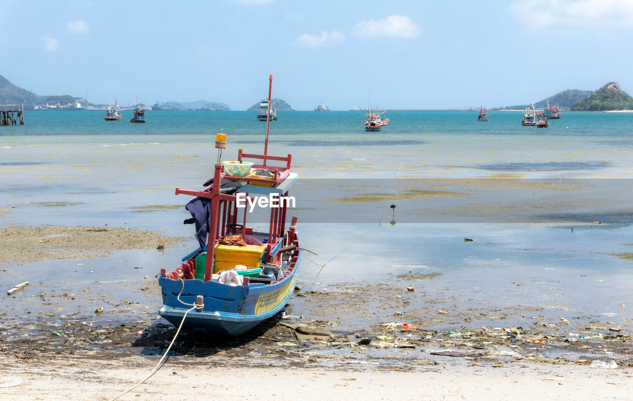 BOAT MOORED ON SHORE