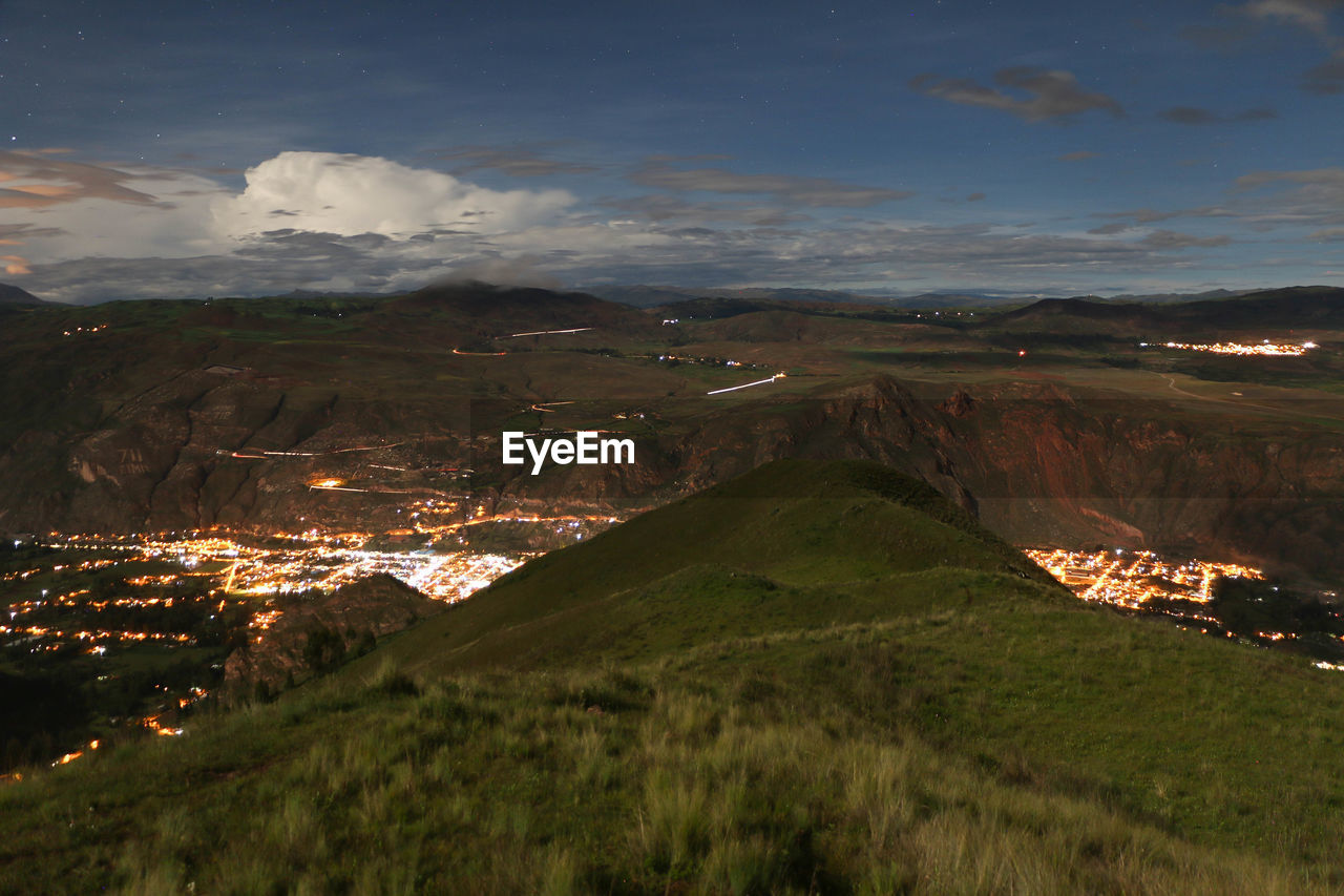 HIGH ANGLE VIEW OF ILLUMINATED LAND AGAINST SKY