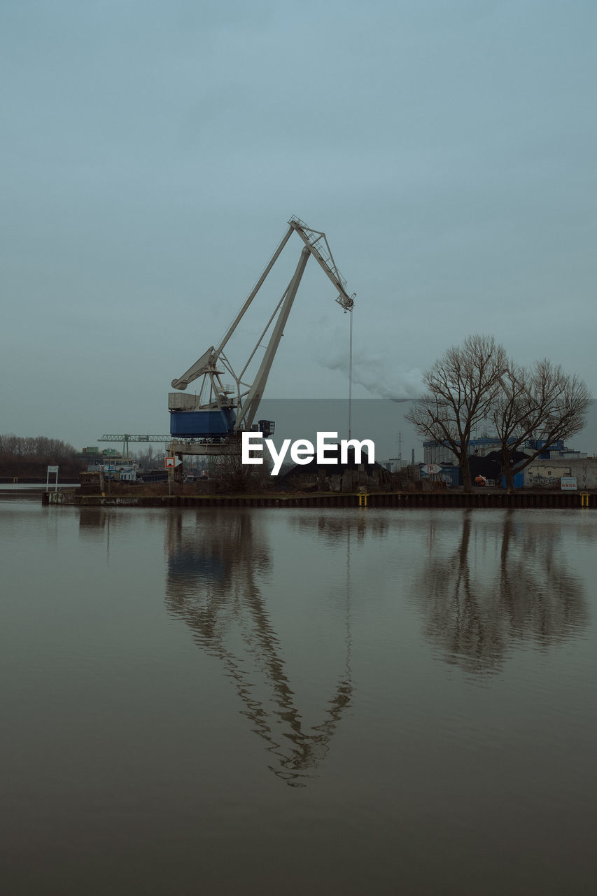 water, reflection, sky, nature, industry, no people, architecture, machinery, crane - construction machinery, morning, lake, outdoors, built structure, vehicle, waterfront, day