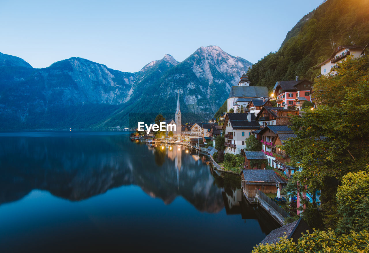 View of buildings by lake against mountain