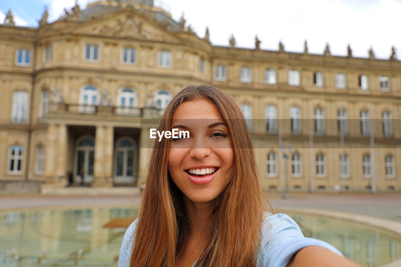 PORTRAIT OF SMILING YOUNG WOMAN