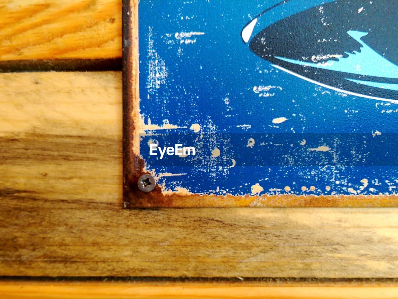 Close-up of weathered picture frame mounted on wooden wall