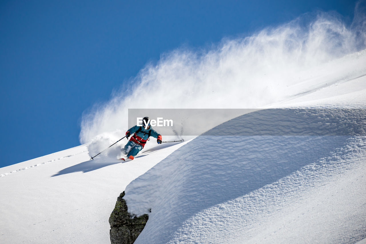 Low angle view of man skiing on snow covered mountain