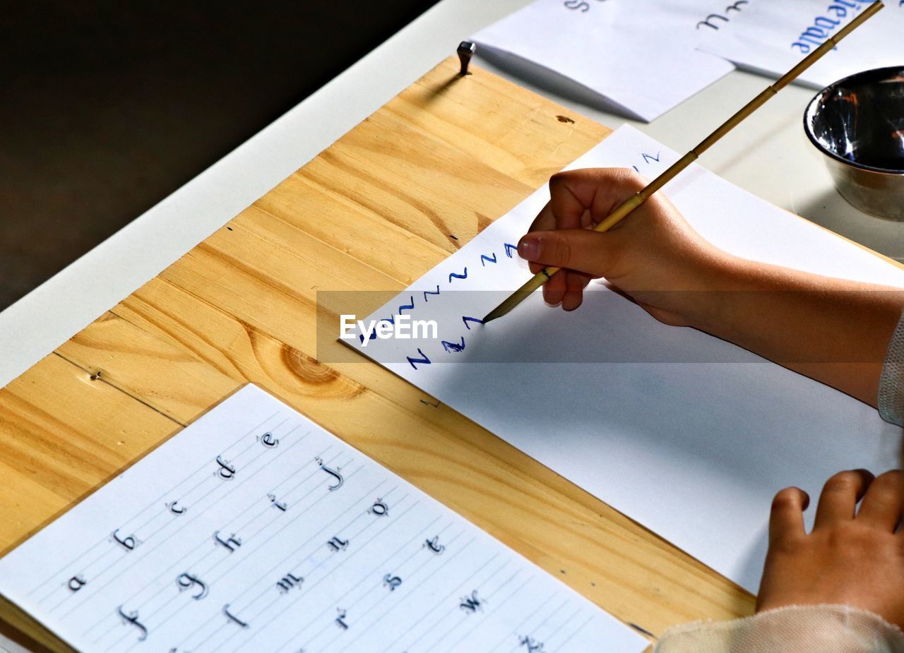 High angle view of hand  doing caligraphy