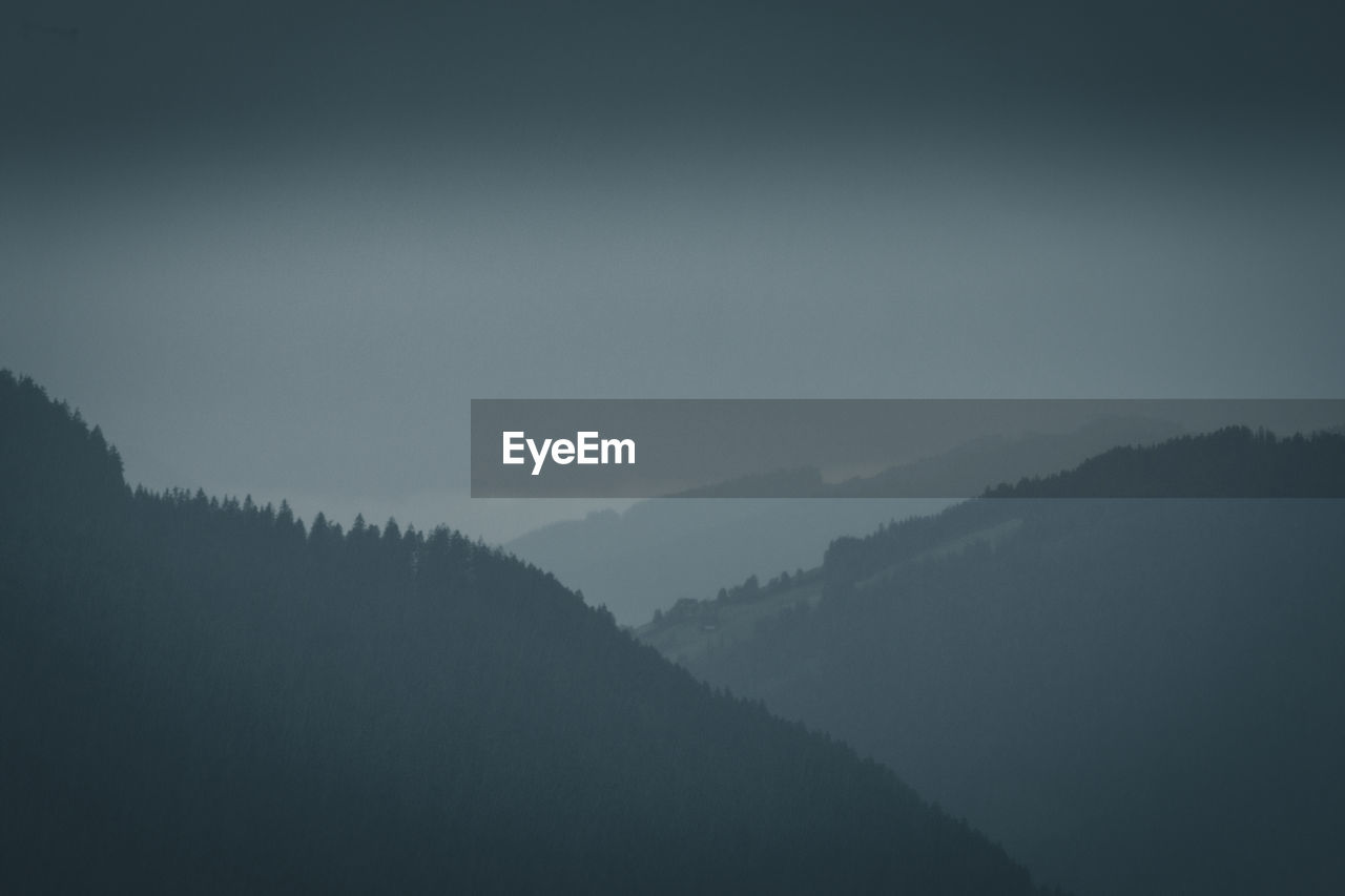 SILHOUETTE TREES ON MOUNTAIN AGAINST SKY