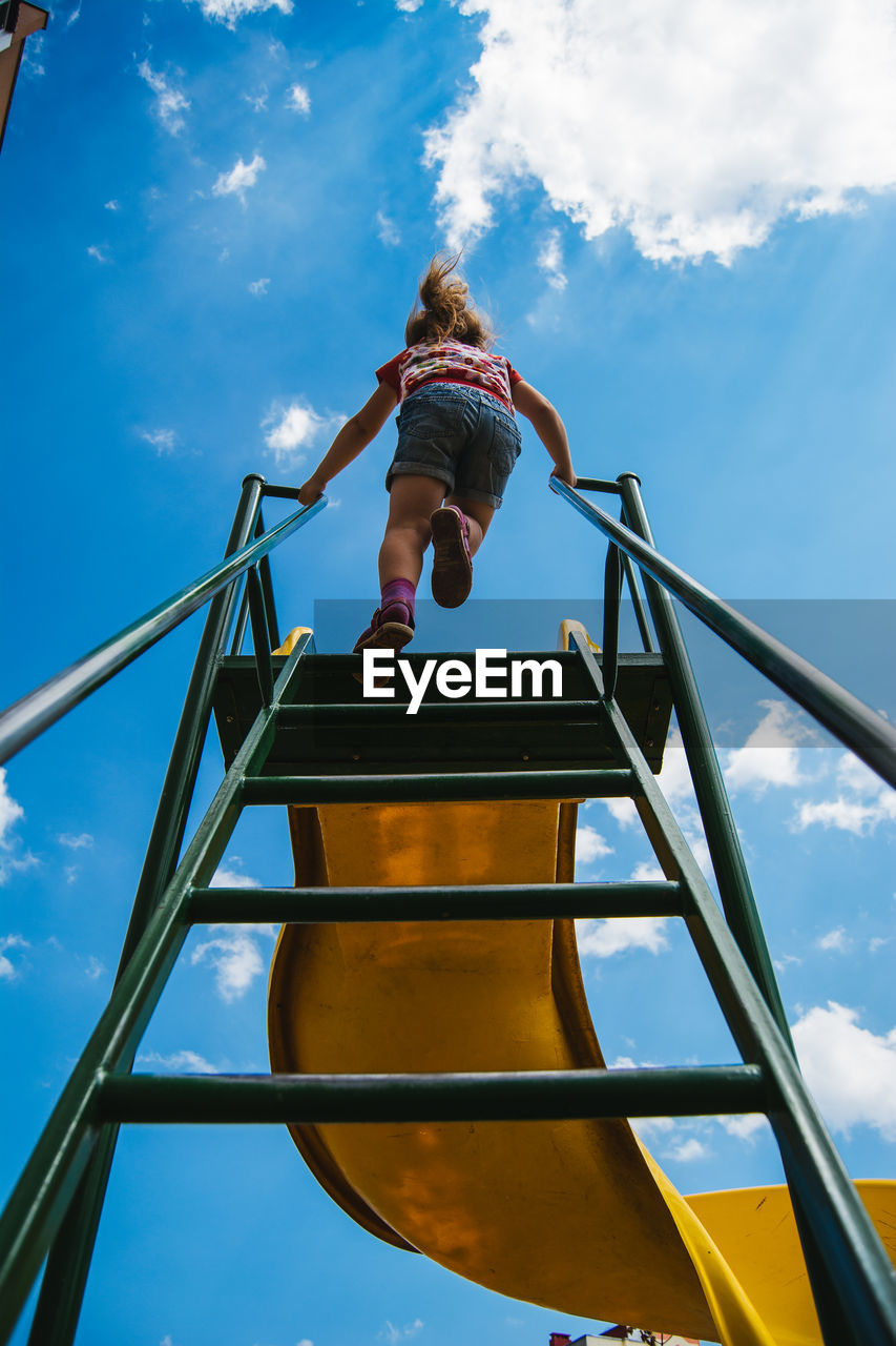 Low angle view of child on slide