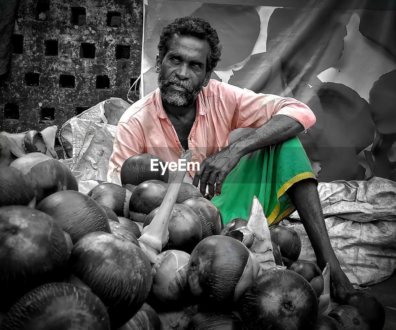 PORTRAIT OF MAN HOLDING FOOD AT MARKET STALL
