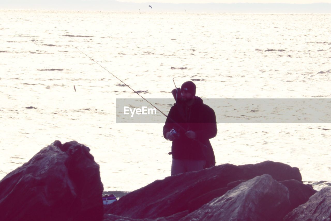 MAN STANDING ON SHORE