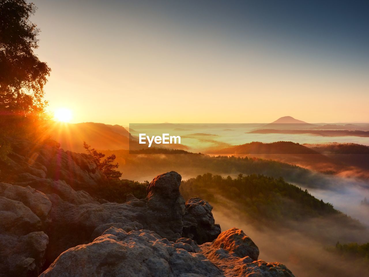 Beautiful autumnal landscape with mountain view, morning foggy valley within sunrise. 