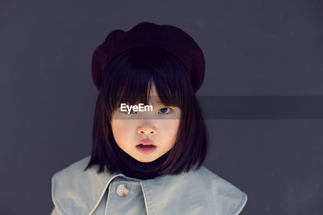 Korean girl in a gray coat and cap and stands the street in spring.