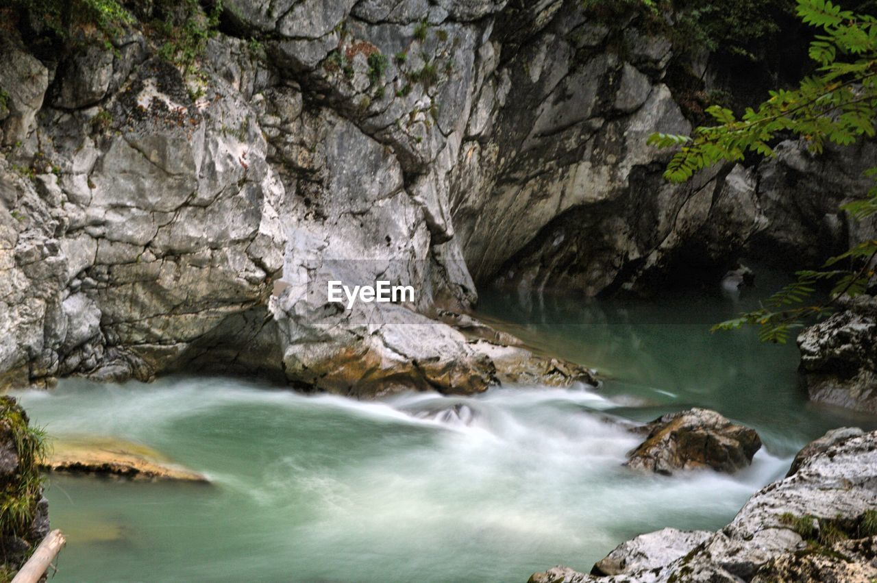 SCENIC VIEW OF WATERFALL ALONG ROCKS