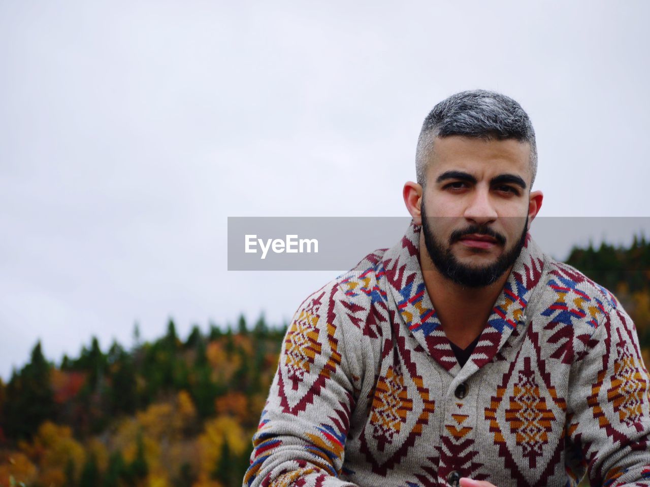 Portrait of confident young man against sky