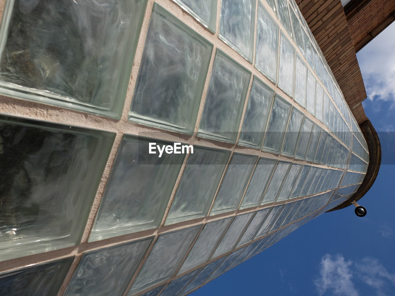 Low angle view of glass tower against sky