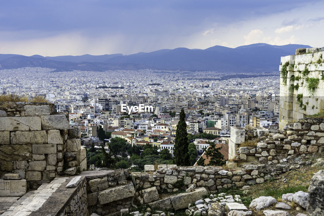View from acropolis over city of athens in front of rain clouds