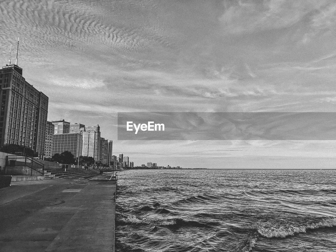 Scenic view of sea by buildings against sky