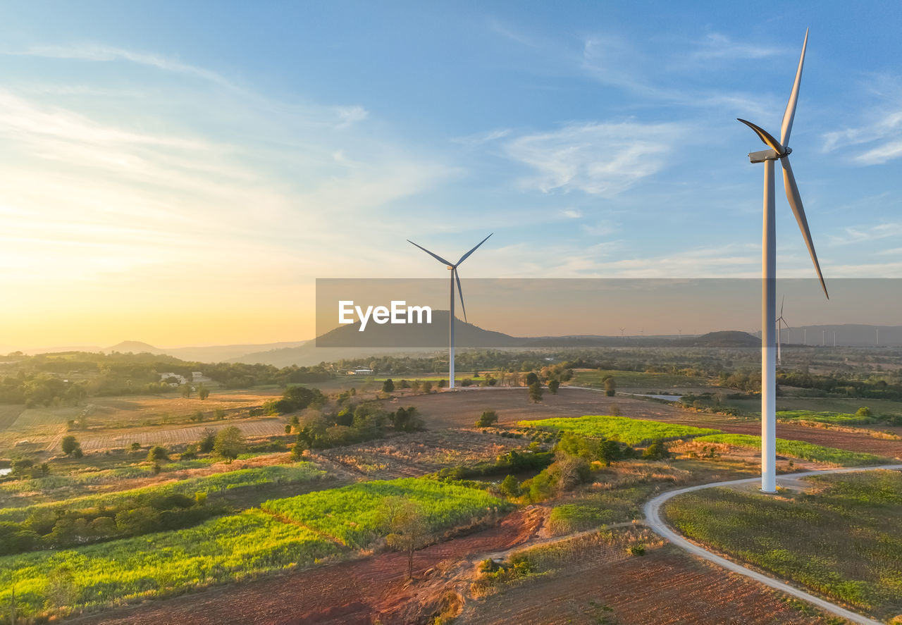 Wind farm field and sunset sky. wind power. sustainable, renewable energy. wind turbines generate