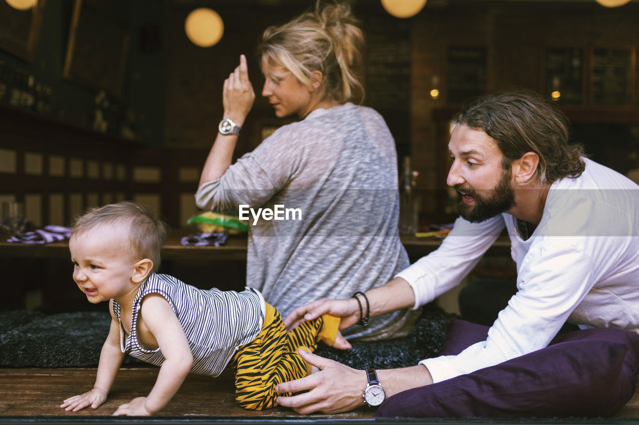 Mid adult parents with playful son in restaurant