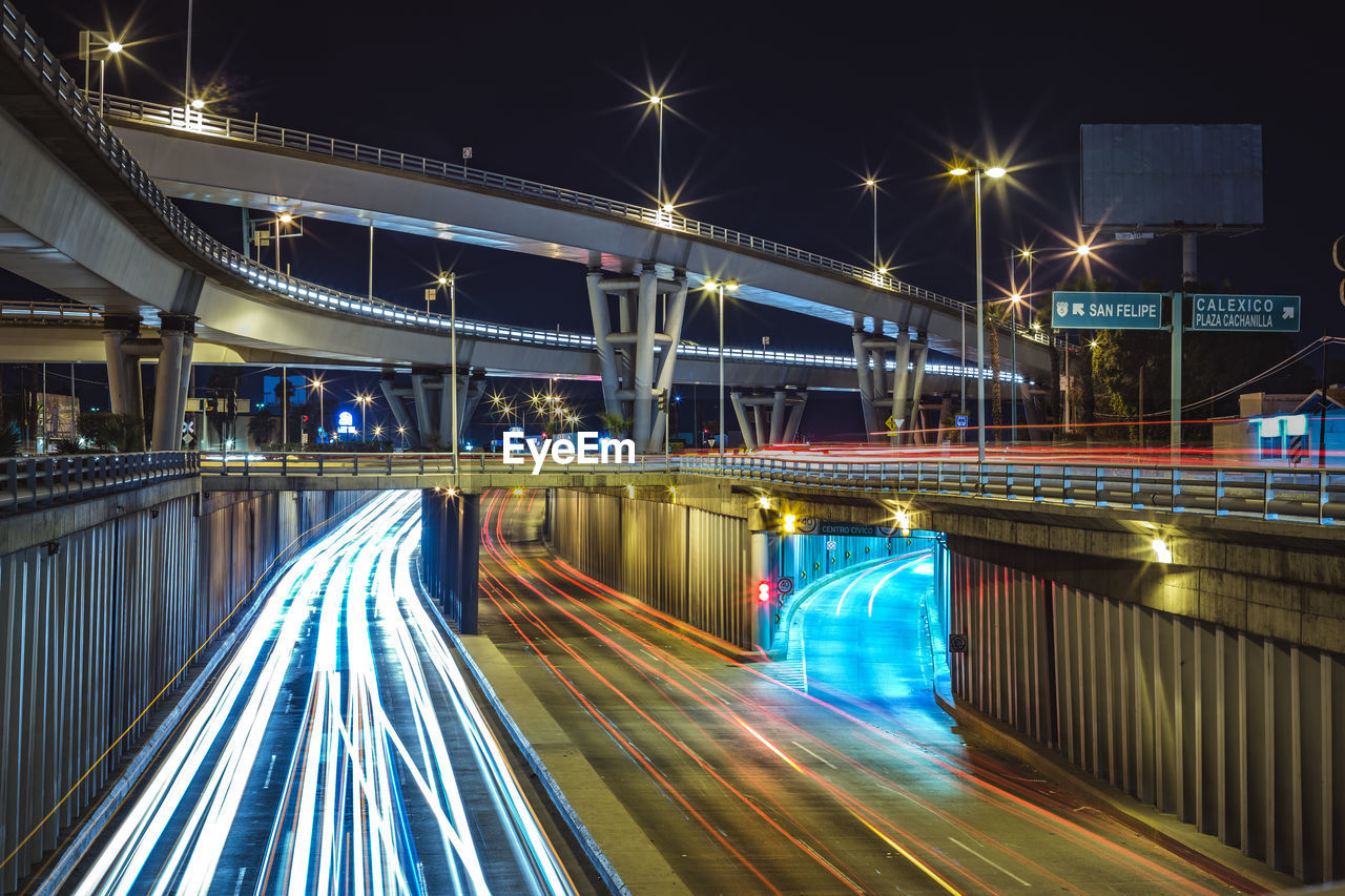 Light trails on bridge in city at night