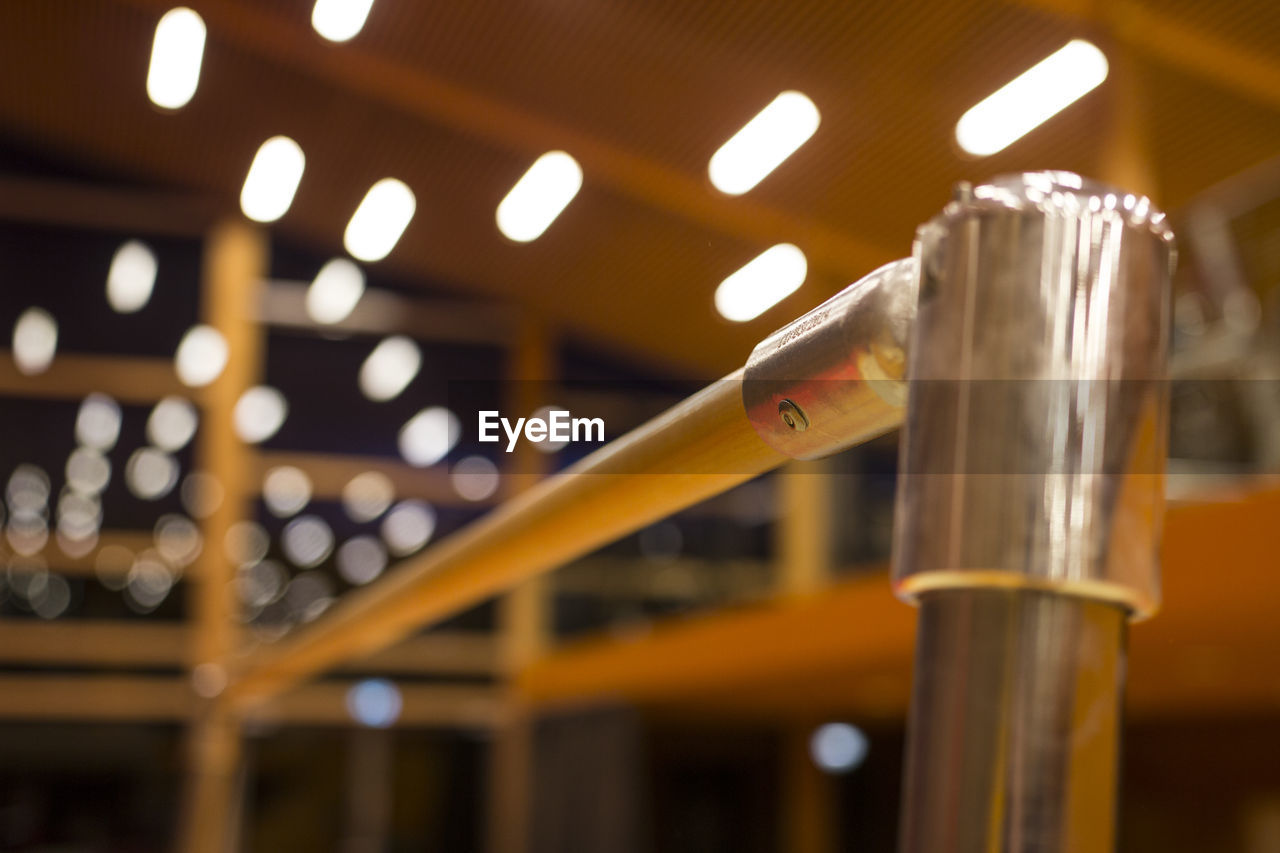 Close-up of railing against illuminated lights