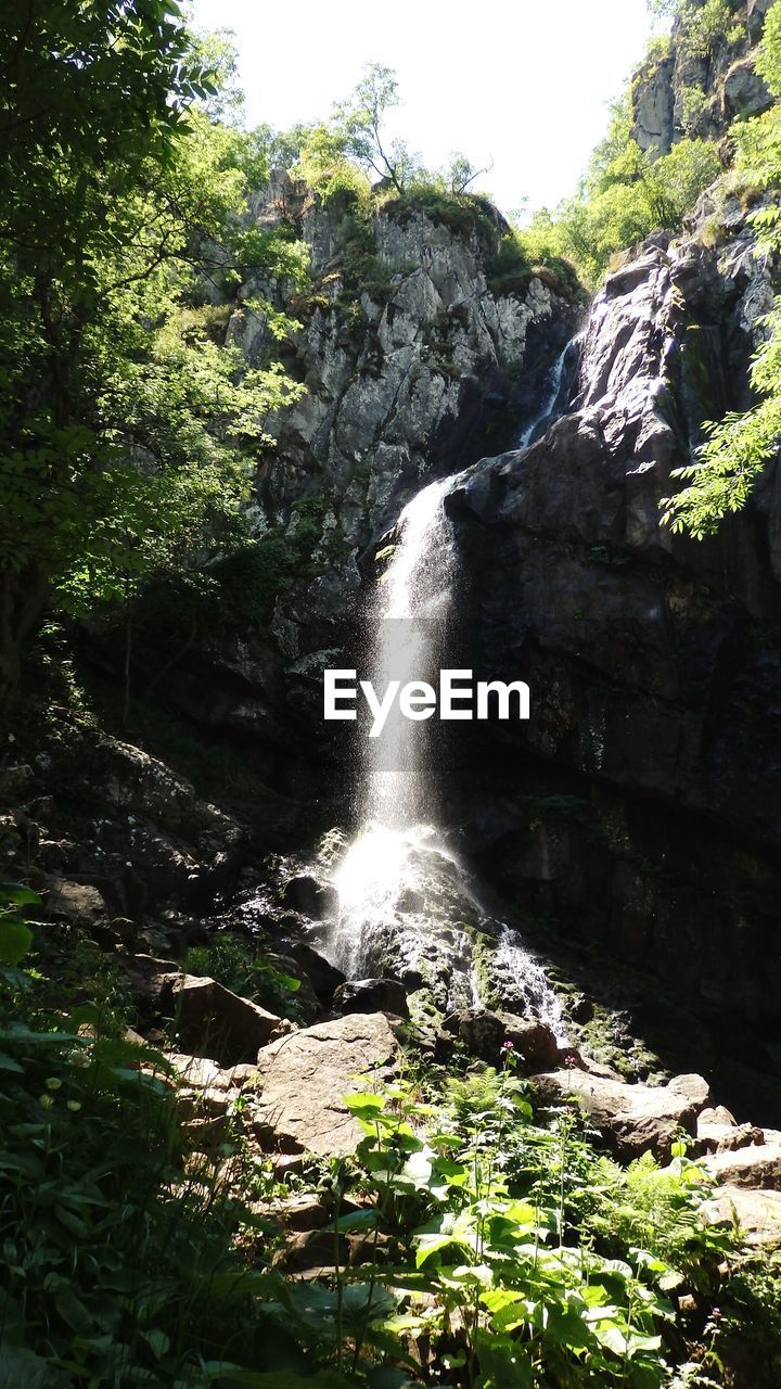 Waterfall among rocks and lush foliage