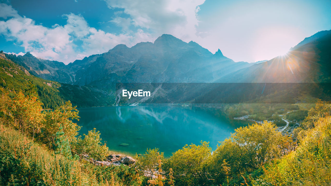 SCENIC VIEW OF LAKE BY MOUNTAINS AGAINST SKY