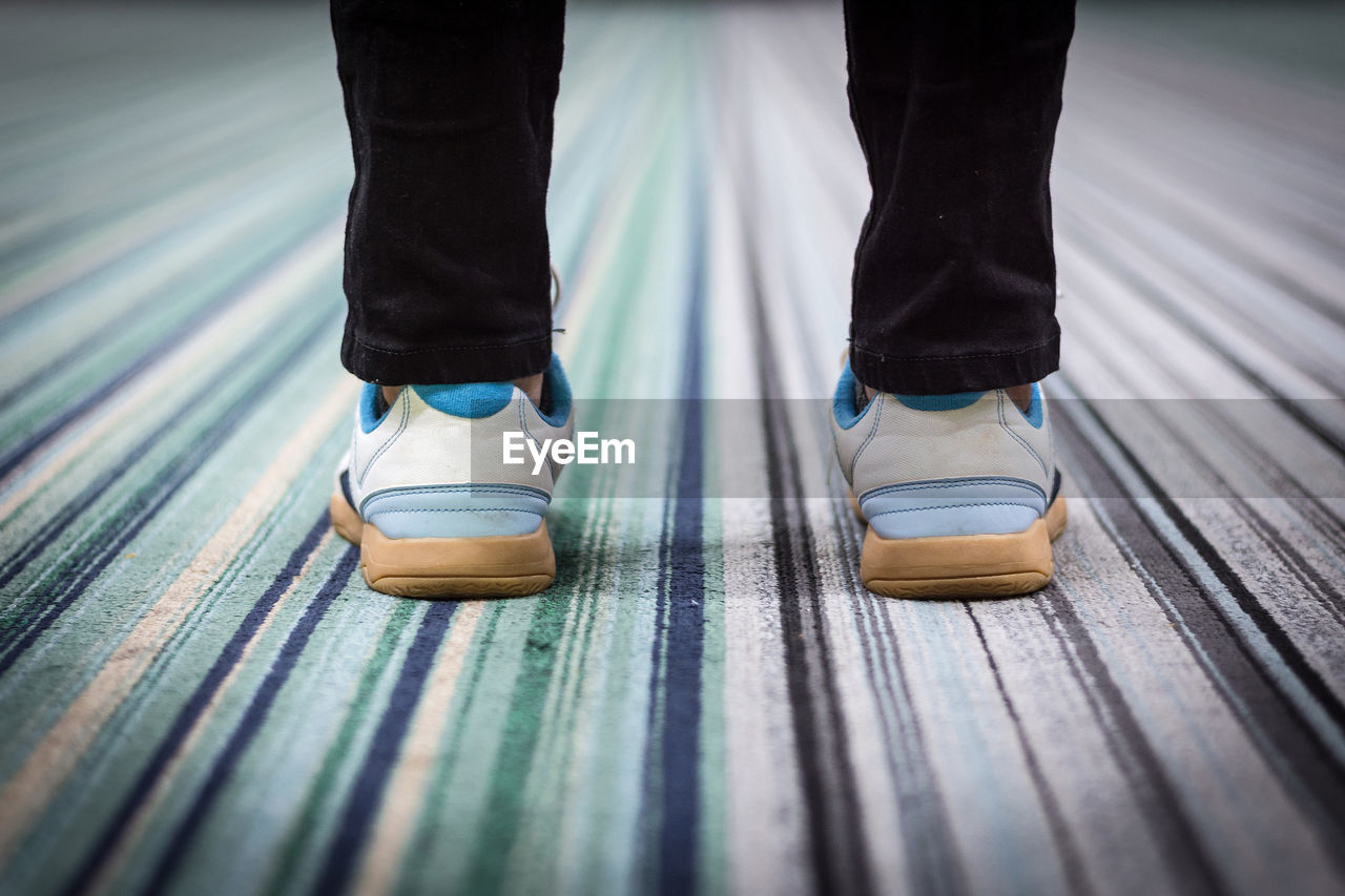 Low section of man standing on carpet