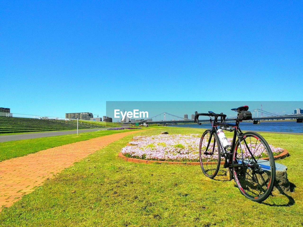 Bicycle on field against clear blue sky