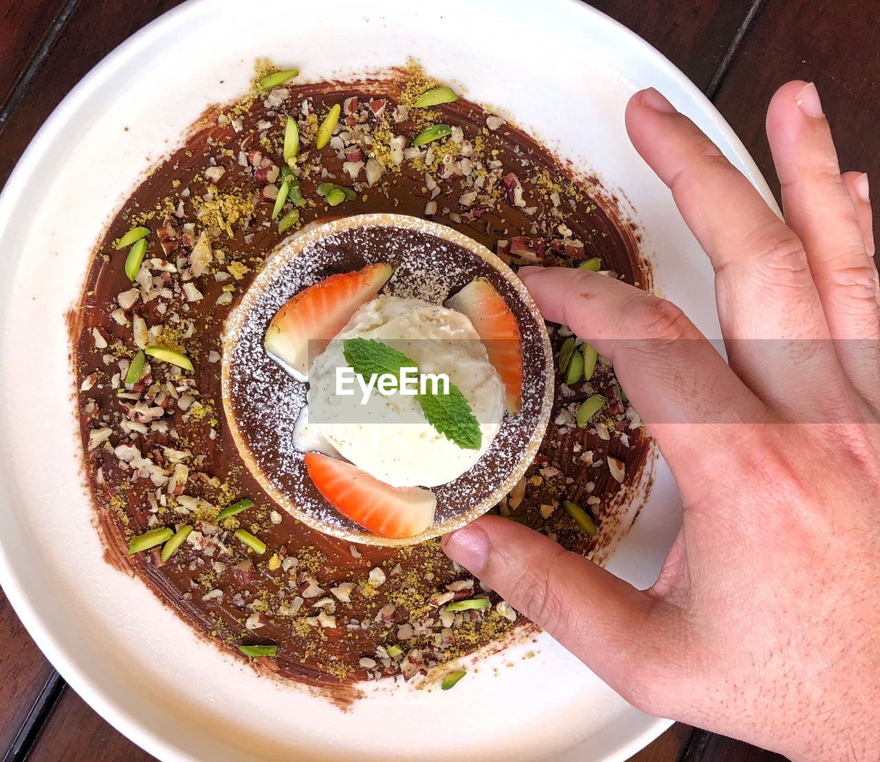 HIGH ANGLE VIEW OF PERSON HAND HOLDING SOUP