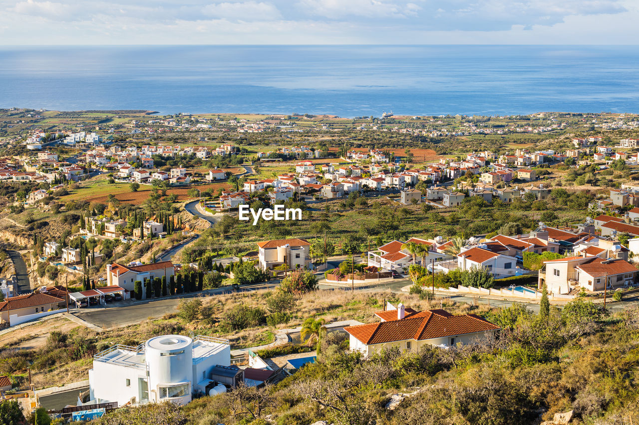 HIGH ANGLE VIEW OF TOWNSCAPE AGAINST SEA