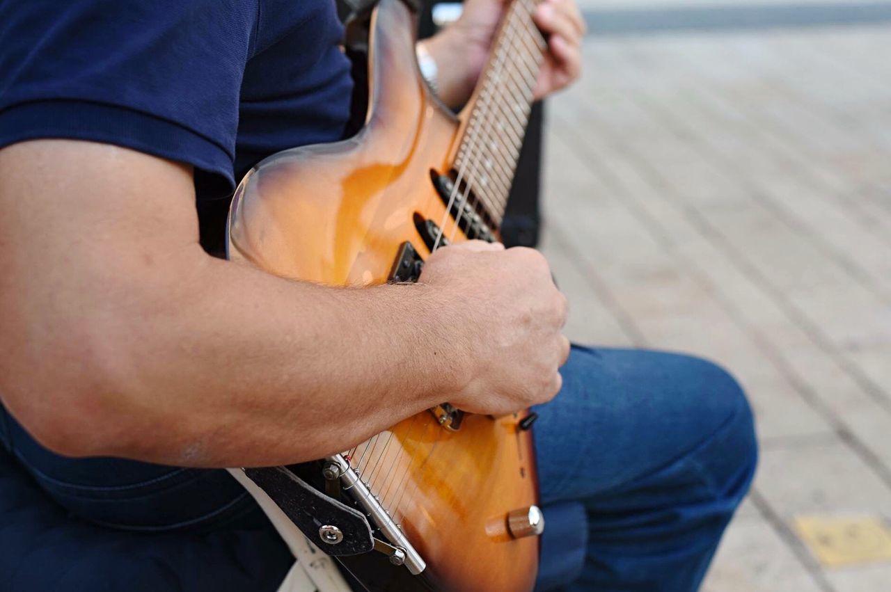 Close-up of man playing guitar outdoors