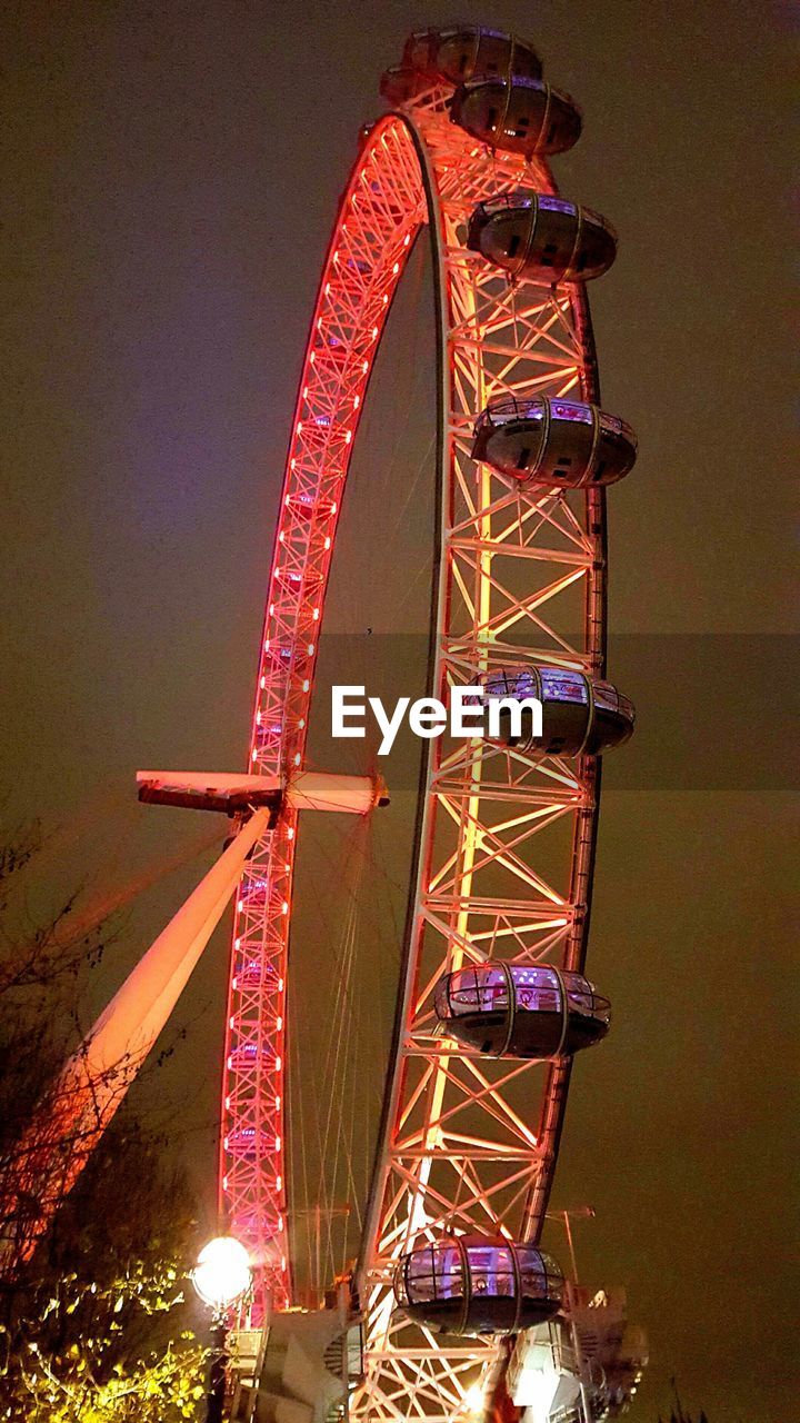 LOW ANGLE VIEW OF ILLUMINATED FERRIS WHEEL AT NIGHT