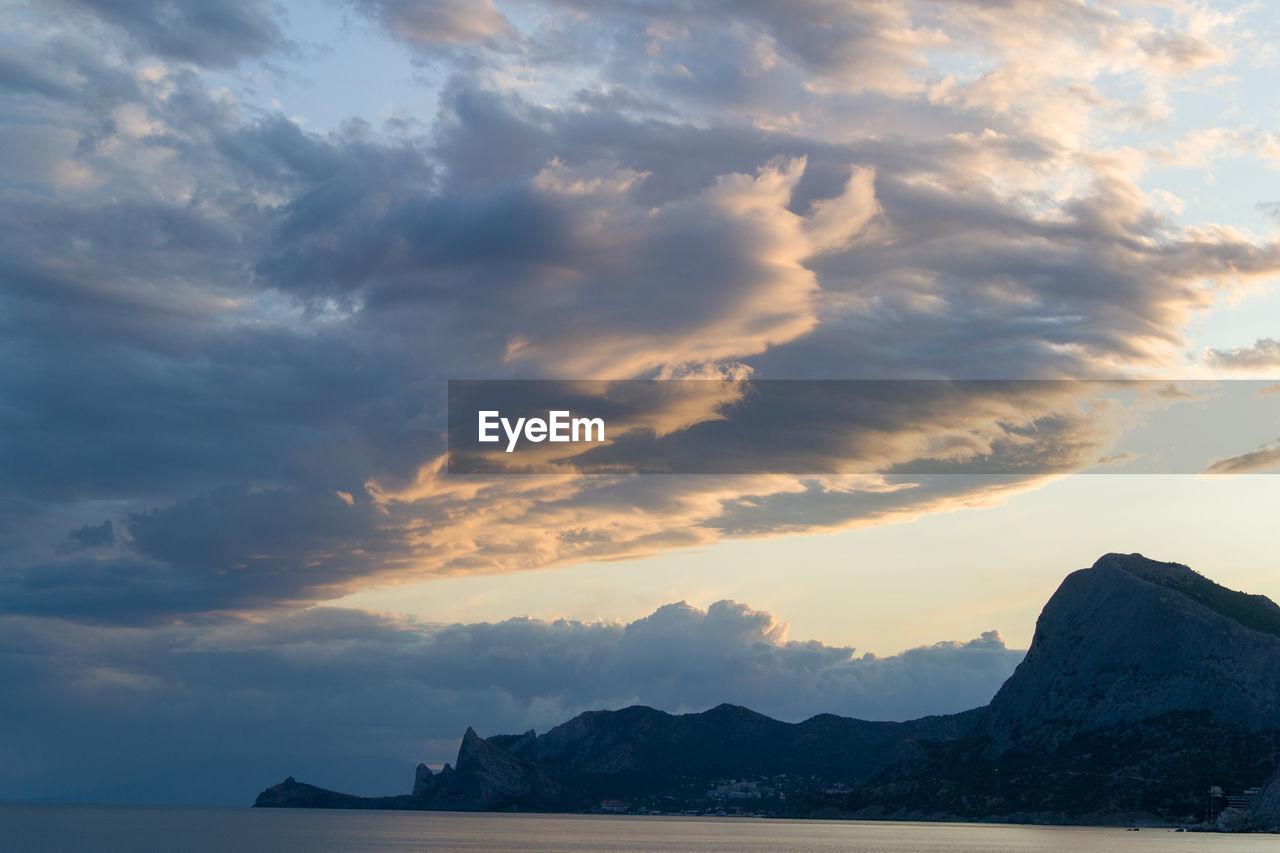 SCENIC VIEW OF SEA AND MOUNTAINS AGAINST SKY DURING SUNSET