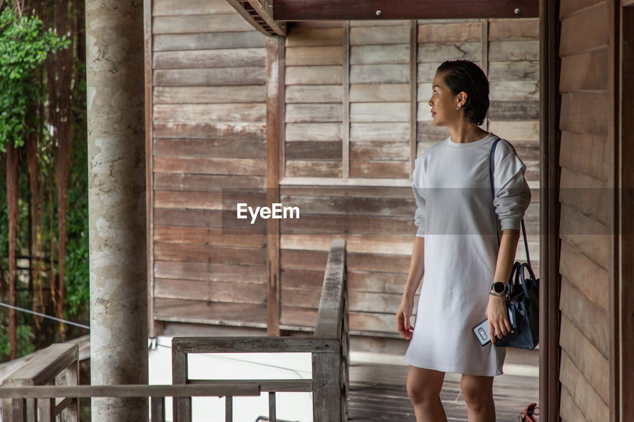 Full length of woman standing against building