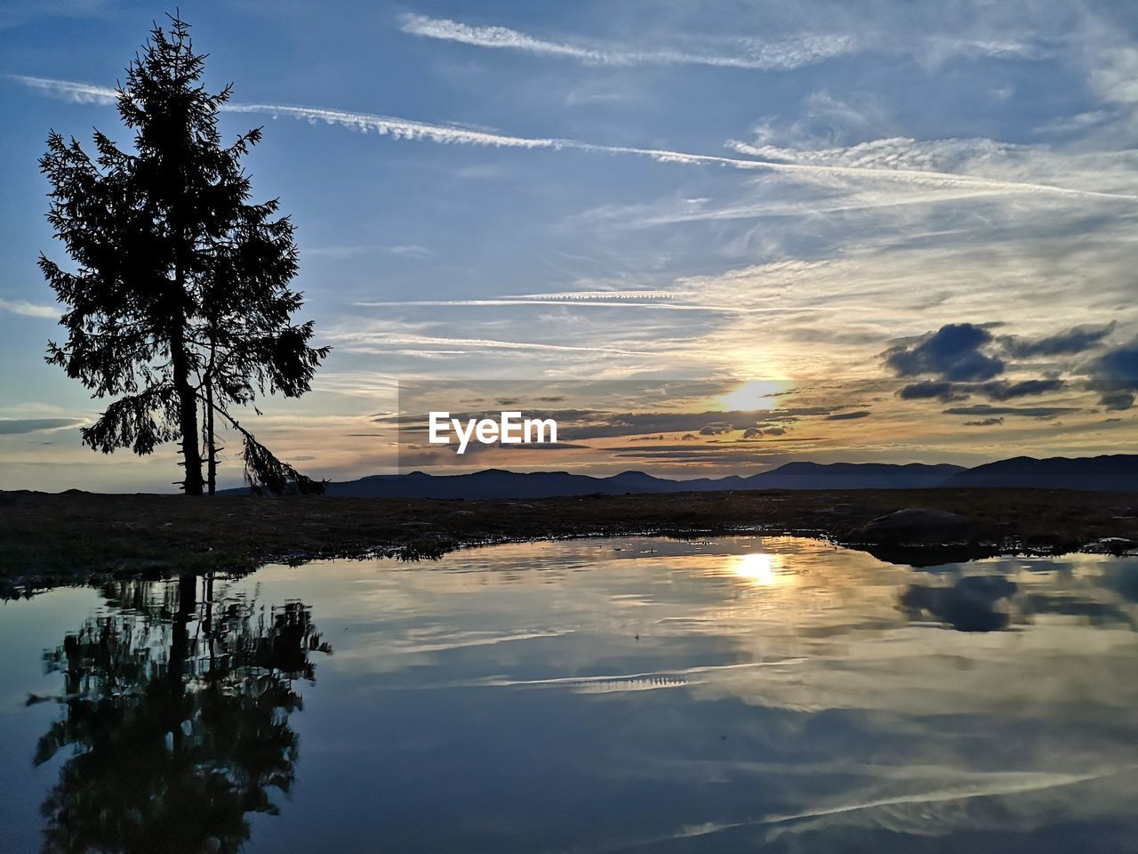 SILHOUETTE TREES BY LAKE AGAINST SKY AT SUNSET