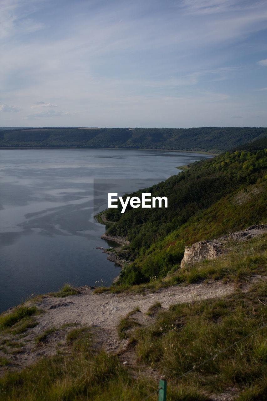water, coast, sky, lake, scenics - nature, beauty in nature, shore, tranquility, body of water, nature, land, tranquil scene, cliff, ocean, cloud, beach, plant, landscape, no people, non-urban scene, reflection, rock, terrain, horizon, environment, day, hill, bay, grass, outdoors, reservoir, idyllic, wilderness, horizon over water, travel destinations