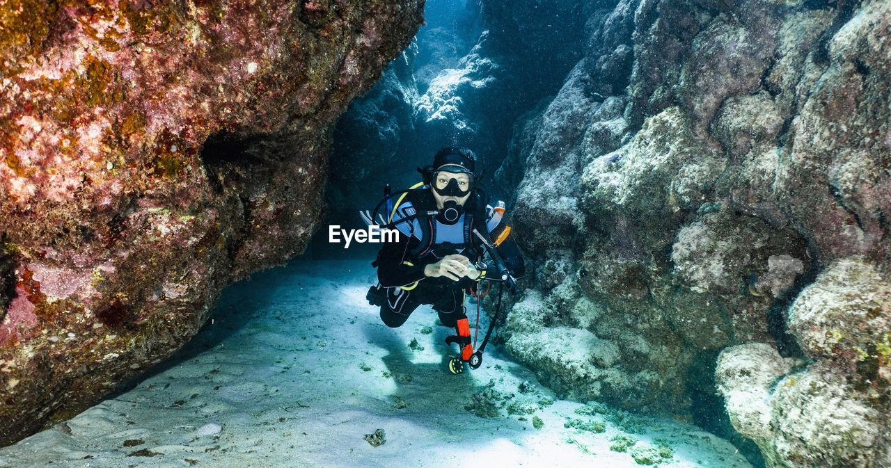 Scuba diver exploring a canyon at the great barrier reef in australia