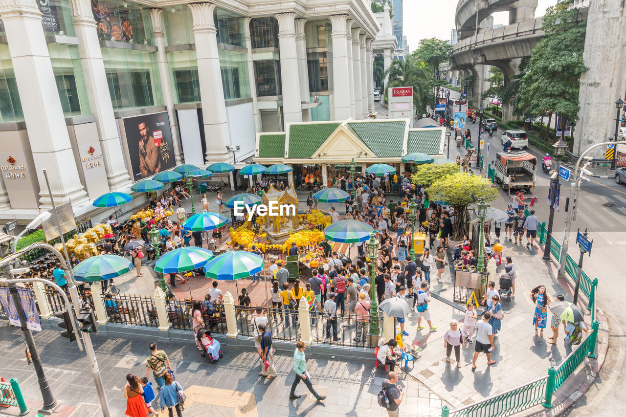 HIGH ANGLE VIEW OF PEOPLE WALKING ON STREET BY BUILDINGS