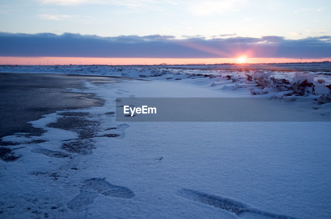Snow covered beach during sunset