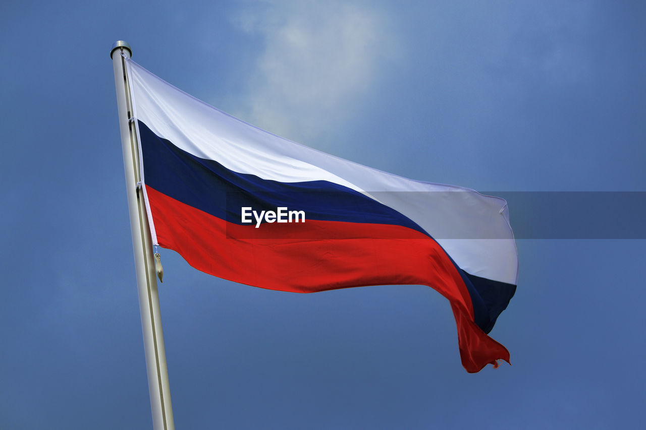 Low angle view of russian flag against blue sky