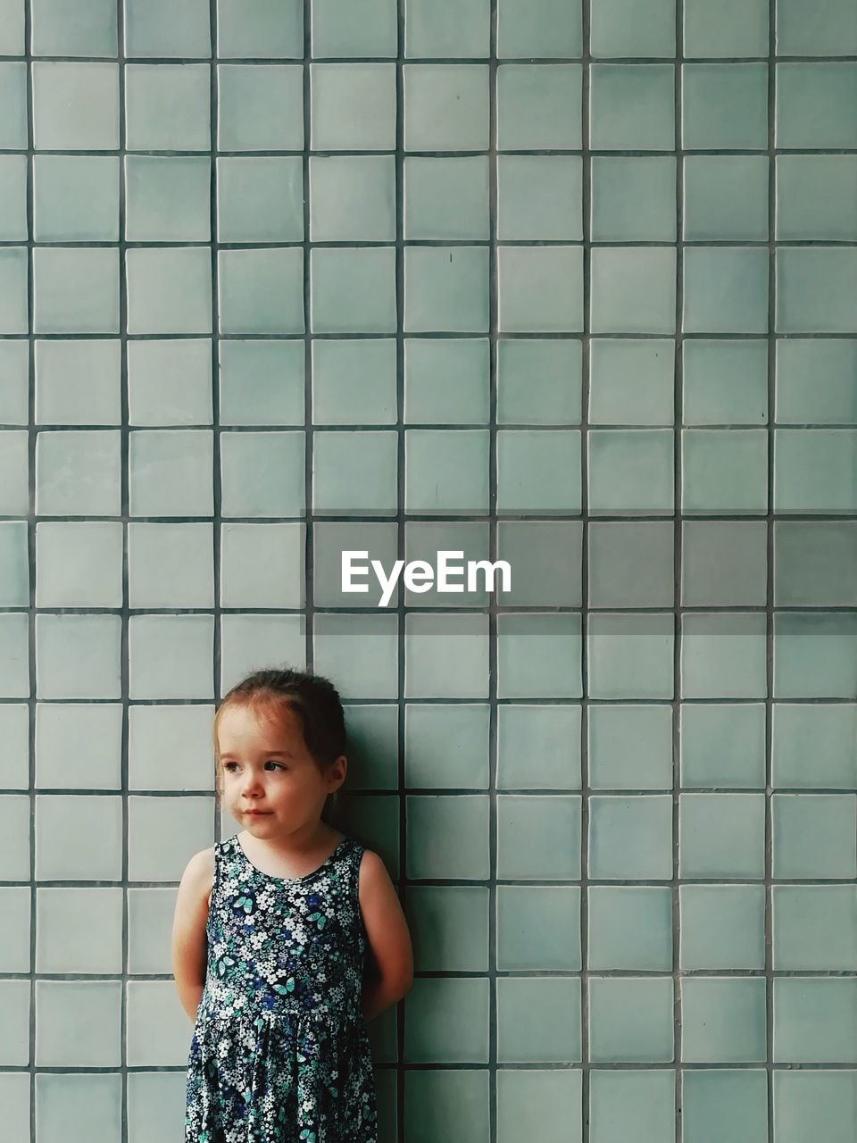 Cute girl standing against wall