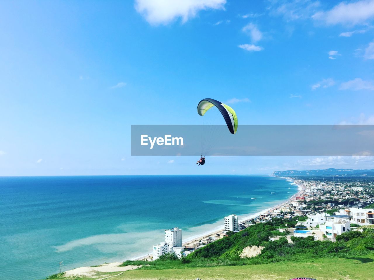 PERSON PARAGLIDING OVER BEACH AGAINST SKY