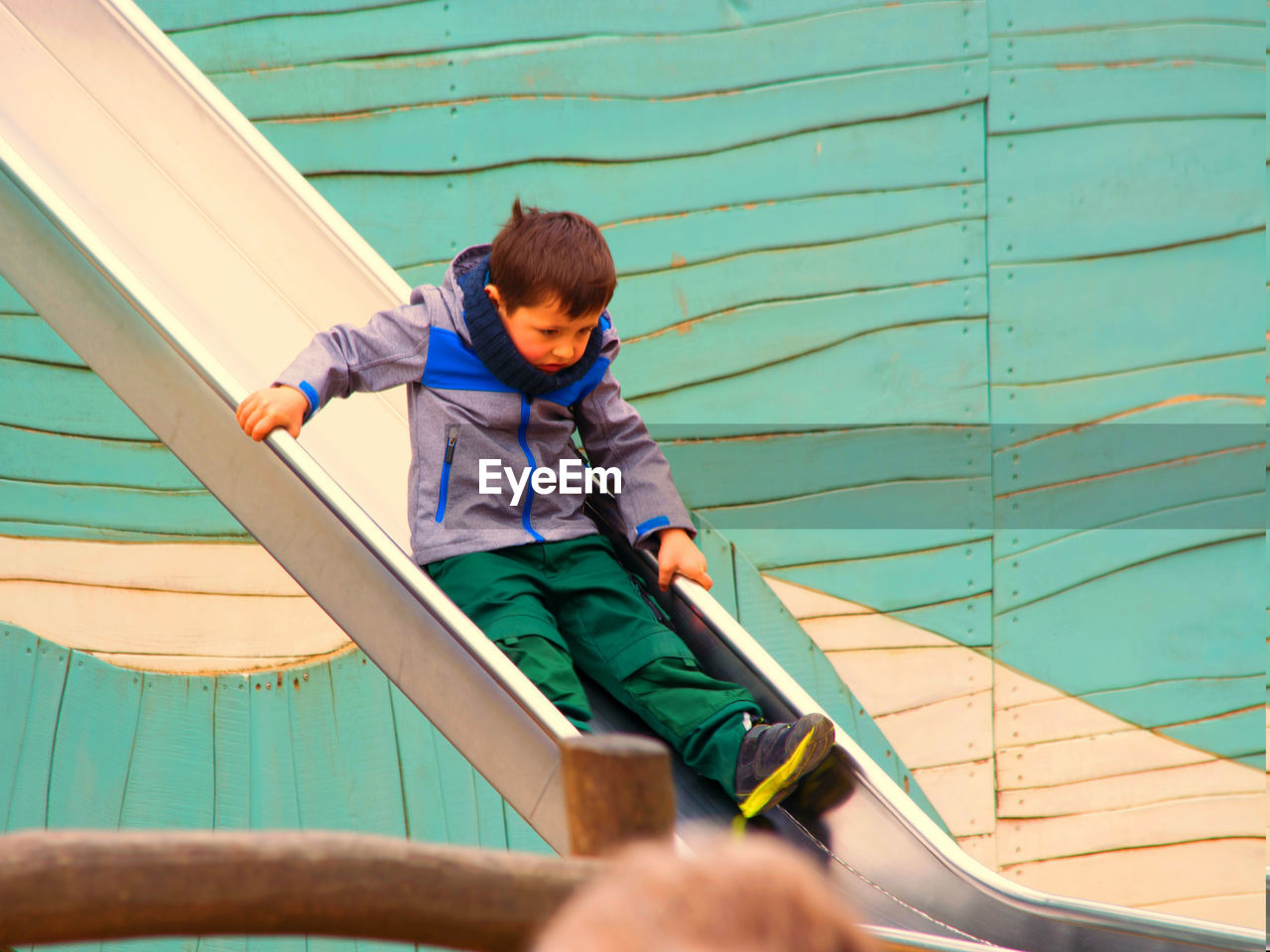 Cute boy playing on slide