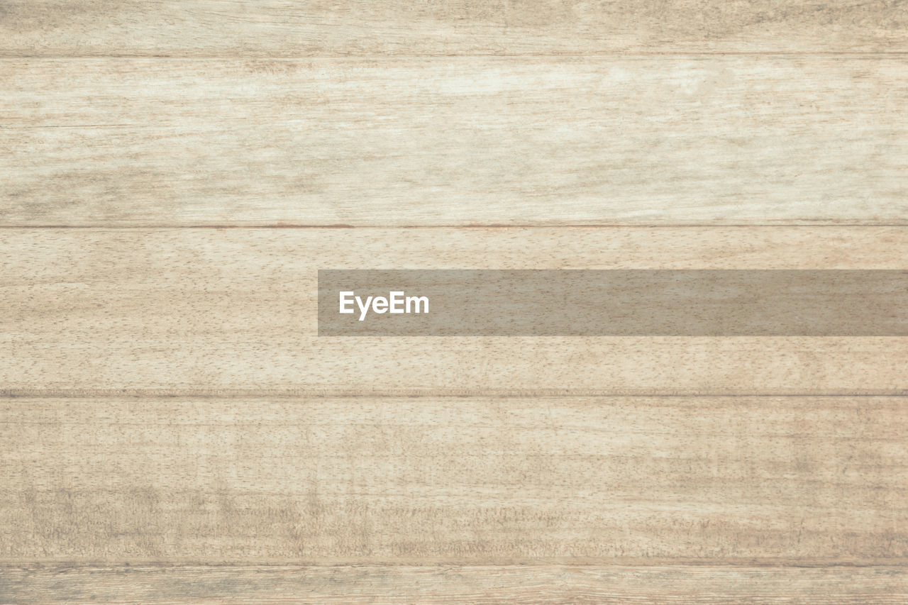 Texture and wood flooring details are background.